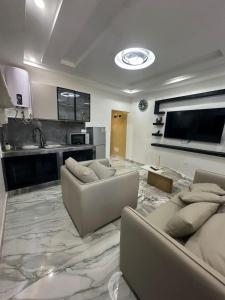 a living room with two couches and a kitchen at La MAISON SEONE PREMIUM in Abidjan