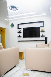 a living room with two couches and a flat screen tv at La MAISON SEONE PREMIUM in Abidjan +3 photos