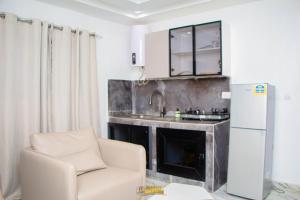a kitchen with a couch and a sink and a refrigerator at La MAISON SEONE PREMIUM in Abidjan