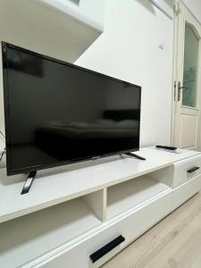 a large flat screen tv sitting on a white entertainment center at Focus Home in Miercurea-Ciuc