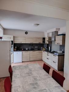 a large kitchen with a table and chairs in it at Gite Agnès & J-Pierre en étage Evasion spa option in Pierre-Châtel