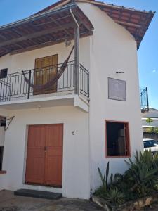 a house with a balcony and a garage at Mini casa Tiradentes in Tiradentes