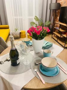 a table with a plate and a bottle of wine at Lotus Apartments Natura parking balcony in Ostrołęka