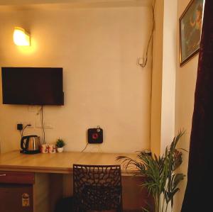 a room with a desk with a television on a wall at Peaceful Stay at Vrindavan in Vrindāvan