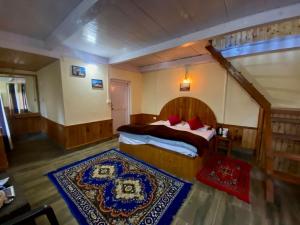 a bedroom with a large bed and a rug at Moksh Jibhi Retreat in Jibhi