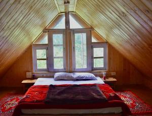 a large bed in a room with a window at Moksh Jibhi Retreat in Jibhi
