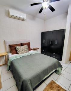 a bedroom with a bed and a ceiling fan at Casa Jaguar 7 in Puerto Morelos