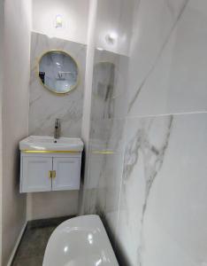 a bathroom with a white toilet and a sink at Casa Jaguar 7 in Puerto Morelos