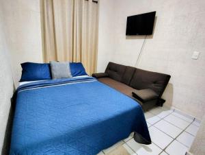a bedroom with a blue bed and a couch at Casa Jaguar 7 in Puerto Morelos