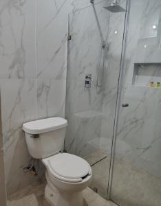a white bathroom with a toilet and a shower at Casa Jaguar 7 in Puerto Morelos