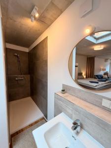 a bathroom with a sink and a shower and a mirror at Sonnenufer Apartment & Wein III in Bernkastel-Kues +13 photos