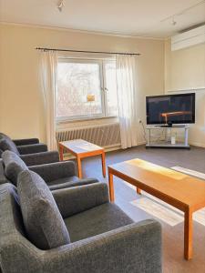 a living room with two couches and a tv at B&B Villa Vila in Löttorp