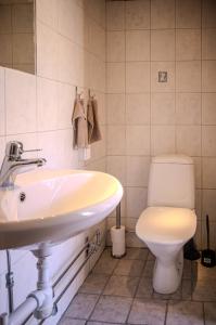 a bathroom with a sink and a toilet at Remarkable Harbour View Cabin. in Östhammar +13 photos