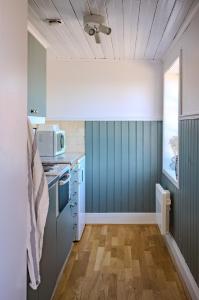 a kitchen with a stove and a microwave at Remarkable Harbour View Cabin. in Östhammar
