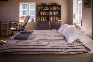 a bedroom with a bed and a book shelf with books at Remarkable Harbour View Cabin. in Östhammar