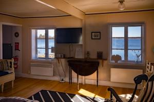 a living room with a television and two windows at Remarkable Harbour View Cabin. in Östhammar