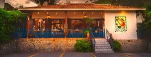 a restaurant with a blue fence in front of a building at Orosi Lodge in Orosí