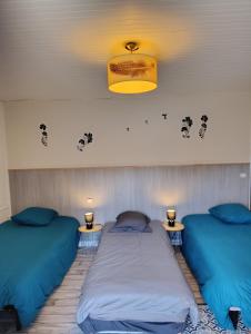 a room with two beds and two lights on the wall at Gite Agnès & J-Pierre en étage Evasion spa option in Pierre-Châtel