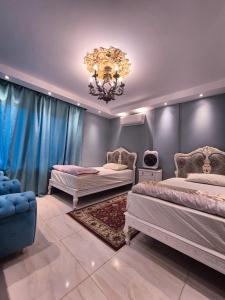 a bedroom with two beds and a chandelier at Galleria 1 in New cairo +14 photos