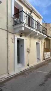 a white building with a balcony on a street at Elia in Kalamoti