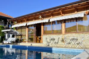 a house with a pool and chairs next to it at Guest house Zlateya in Madara
