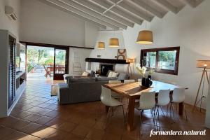 a living room with a couch and a table with chairs at Casa Lilu Playa Migjorn - Formentera Natural in Playa Migjorn