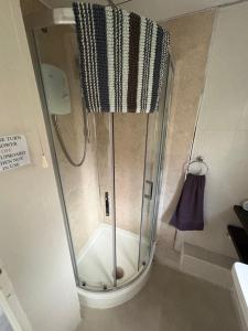 a shower with a glass door in a bathroom at Modern retreat in Caernarfon +3 photos