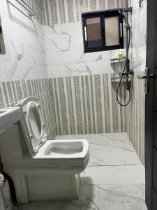 a bathroom with a toilet and a shower in it at La MAISON SEONE STANDARD in Abidjan