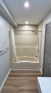 a bathroom with a tub and a shower in a room at Wellington Inn in Bracebridge +20 photos