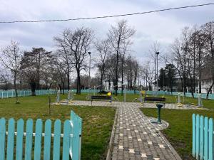 a park with benches and a blue fence at Karina Maliuc Apartment in Maliuc +83 photos