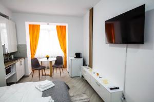 a room with a bed and a table with chairs at Sun Studio Onești in Onești
