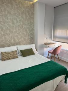 a bedroom with a large bed with a green blanket at Casa da Fonte in Rianjo +16 photos