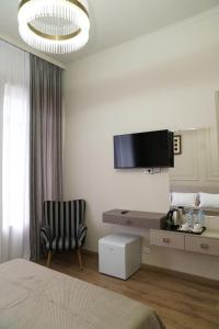 a bedroom with a bed and a chair and a television at EL hotel in Kutaisi