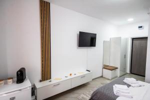 a white room with a bed and a mirror at Sun Studio Onești in Onești
