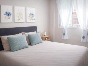a bedroom with a white bed with two pillows at Fenals Calm - con piscina in Lloret de Mar