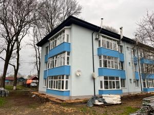 a blue and white building with a lot of windows at Karina Maliuc Apartment in Maliuc