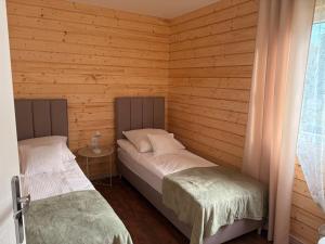 a bedroom with two beds in a wooden cabin at Accommodation under the Oaks in Dramino