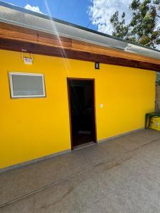 a yellow building with a door in it at Suítes Mazzioni in Socorro