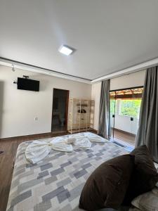 a bedroom with a large bed with a television on the wall at Suítes Mazzioni in Socorro +10 photos