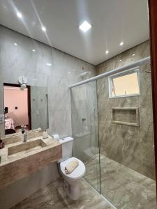 a bathroom with a shower and a toilet and a sink at Suítes Mazzioni in Socorro