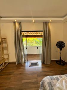 a bedroom with a bed and a large window at Suítes Mazzioni in Socorro