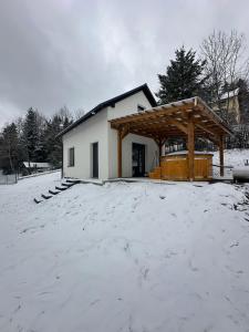 a house in the snow with a pavilion at Domek Nad Rykowiskiem in Jeleśnia +2 photos