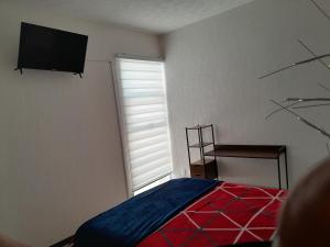 a bedroom with a bed and a television on the wall at DePA DRAGON in Tizayuca +10 photos