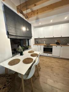 a kitchen with a table and chairs and a fireplace at Domek Nad Rykowiskiem in Jeleśnia