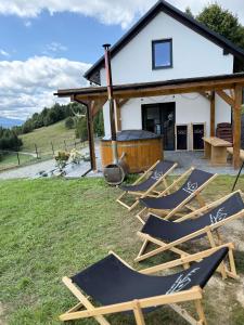 a group of lawn chairs in front of a house at Domek Nad Rykowiskiem in Jeleśnia