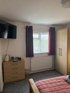 a bedroom with a bed and a dresser and a window at The BILLINGFORD HORSESHOES in Scole