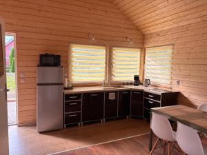 a kitchen with a refrigerator and a table and two windows at Accommodation under the Oaks in Dramino