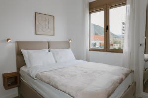 a white bedroom with a large bed with a window at Bella Vista Residence with private Free Parking in Baošići +71 photos