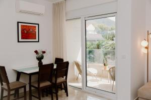 a dining room and living room with a table and chairs at Bella Vista Residence with private Free Parking in Baošići