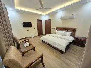 a hotel room with a bed and a couch at Regency Guest House Peshawar in Peshawar +82 photos